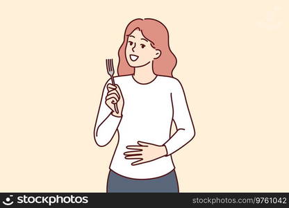 Hungry woman with fork in hands touches stomach, demonstrating good appetite and desire to dine. Hungry girl needs food and looks at screen with smile, waiting for waiter with order. Hungry woman with fork in hands touches stomach, demonstrating good appetite and desire to dine