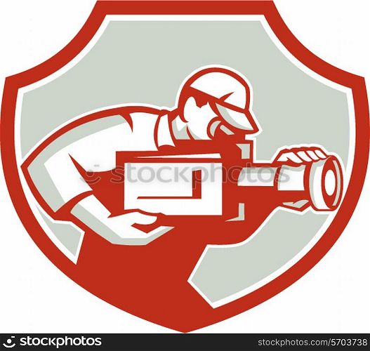 Illustration of a cameraman film crew shooting looking down on lens of video movie camera viewed from the side set inside shield crest done in retro style on isolated background. . Cameraman Film Crew Camera Shield Retro
