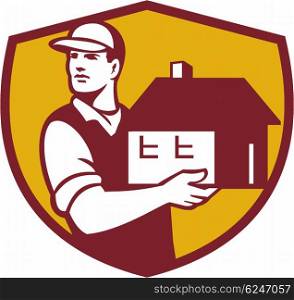Illustration of a house mover handling holding house looking to the side set inside shield crest on isolated background done in retro style. . Mover Handling House Crest Retro