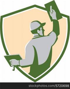 Illustration of a plasterer masonry tradesman construction worker with trowel viewed from the back set inside shield crest done in retro style on isolated background. Plasterer Masonry Trowel Shield Retro