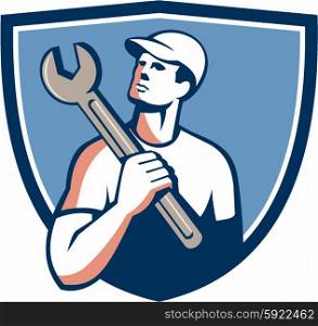 Illustration of a tradesman mechanic wearing hat holding spanner on shoulder looking up to the side set inside shield crest on isolated background done in retro style. . Tradesman Mechanic Spanner Crest Retro