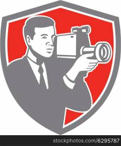 Illustration of a video cameraman carrying vintage video camera shooting set inside shield crest on isolated background done in retro style. . Video Cameraman Shooting Vintage Shield Retro