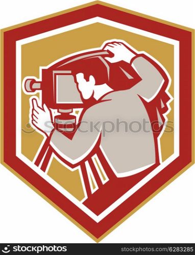 Illustration of a vintage movie film camera with photographer setting it up set inside shield crest shape done in retro woodcut style.. Vintage Film Camera Shield Retro