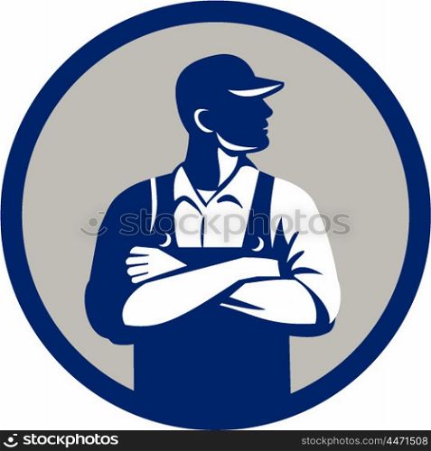Illustration of an organic farmer wearing hat and overalls arms folded looking to the side viewed from front set inside circle on isolated background done in retro style.