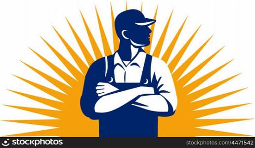 Illustration of an organic farmer wearing hat and overalls arms folded looking to the side viewed from front with sunburst in the background done in retro style.
