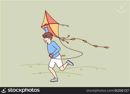 Little boy with kite runs through meadow enjoying summer walk with favorite toy. Happy kid laughing while flying kite for concept of carefree childhood and teen outdoor activity. Little boy with kite runs through meadow enjoying summer walk with favorite toy.