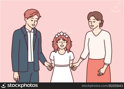 Little girl along with father and mother on day of holy communion according to christian catholic traditional rite. Preteen girl in white elegant dress participates in communion ceremony with parents. Little girl along with father and mother on day of holy communion according to christian rite