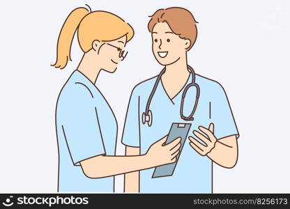 Man and woman dressed as doctors are discussing with smile treatment of patient or correct diagnostic measures. Guy with girl work as doctors surgeons in hospital and build career in field of medicine. Man and woman work as doctors surgeons in hospital and build career in field of medicine