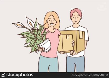 Man and woman move into new house together after buying own property with mortgage or renting apartment in good area. Guy with moving boxes and girl with house plant looking at camera. Man and woman move into new house together after buying own property with mortgage 