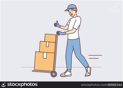 Man at warehouse employee carries cargo cart with cardboard boxes and shows thumbs up. Delivery service employee working in warehouse enjoys cool job in courier or logistics business . Man at warehouse worker carries cargo cart with cardboard boxes and shows thumbs up