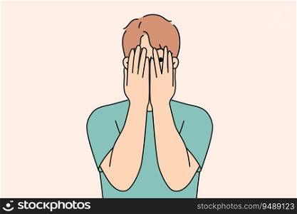 Man closes eyes with hands and peeps, feeling excited in anticipation of surprise or panic after receiving threats. Guy feels insecure and panic, trying to hide from problems that have arisen.. Man closes eyes with hands and peeps, feeling excited in anticipation of surprise or panic