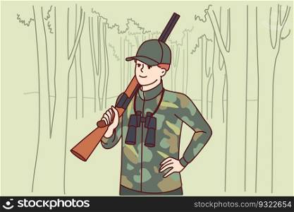Man hunter with double-barreled gun stands in forest with binoculars to track down wild animal and search for prey. Gamekeeper guy protects animals from national park from hunter or poacher. Man hunter with double-barreled gun stands in forest with binoculars to track down wild animal