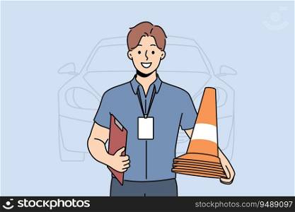 Man instructor from driving school smiles and holds traffic cones inviting to take exam for driver license. Guy employee of car school advertises services company teaching driving.. Man instructor from driving school smiles and holds traffic cones inviting to take exam for license