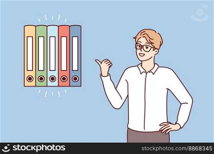 Man office worker points finger at multicolored folders for documents. Guy in business clothes gives advice on finding reports or recommends system for storing financial papers. Flat vector image . Man office worker points finger at multicolored folders for documents. Vector image