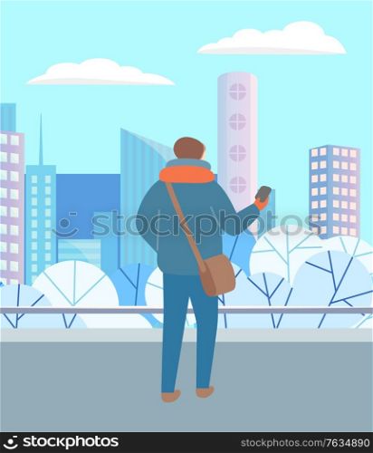 Man walking through urban winter park alone. Person in warm clothes, hat and scarf standing with telephone in hand. Beautiful snowy landscape of city on background. Vector illustration in flat style. Man Walking in Winter Park Alone, City Landscape