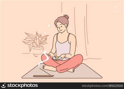 Meditating woman does yoga and uses aroma candles during spiritualistic session and sits in lotus position. Meditating girl wants to achieve awareness or get rid of psychological problems.. Meditating woman does yoga and uses aroma candles during spiritualistic session.