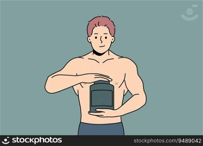 Muscular man holds jar of protein and recommends taking sports nutrition while doing bodybuilding. Strong guy with big muscles on arms takes protein to achieve outstanding result from training.. Muscular man holds jar of protein and recommends taking sports nutrition while doing bodybuilding