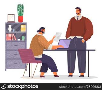 Office working space. Bearded man with fashionable haircut sits on chair at table, works at laptop, typing document. Black-haired man stands and smiles. Bookcase with books, folders, potted plant. Office workers in office. Bearded man smiles, employee sits at table, holds document, typing