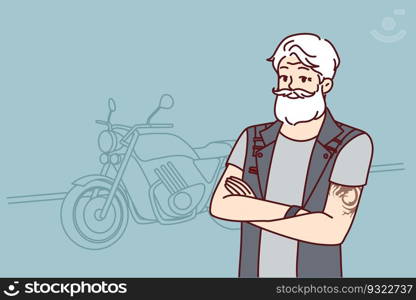 Old biker near motorcycle wishes to travel after retirement. Confident old man with tattoo on arms and gray hair is wearing biker vest for traveling around city or country on motorcycle. Old biker near motorcycle with tattoo on arms and gray hair wishes to travel after retirement