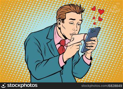 online date and love a man kisses a womans hand via smartphone. Pop art retro vector illustration. online date and love a man kisses a womans hand via smartphone