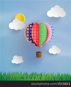 Origami made colorful hot air balloon fly over grass.paper art style.