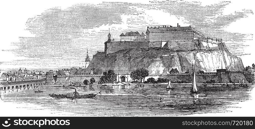 Petrovaradin Fortress in Novi Sad, Serbia, during the 1890s, vintage engraving. Old engraved illustration of Petrovaradin Fortress with river and boats in front.