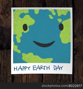 Photo frame with Earth snapshot closeup. Earth day concept. On wooden background.