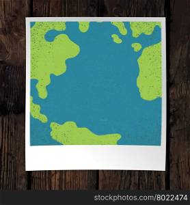 Photo frame with Earth snapshot closeup. Earth day concept. With space for text. On wooden background. Design template.