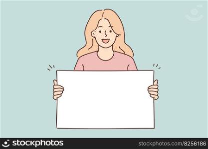 Positive woman holding blank white placard smiling and looking at camera demonstrating banner with copy space. Young girl teenager shows blank banner for presentation of promotional product . Woman holding blank white placard smiling and looking at camera demonstrating banner with copy space