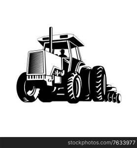Retro style illustration of farm tractor pulling a plow or plough while plowing viewed from front on low angle on isolated background done in black and white.. Farm Tractor Pulling a Plow or Plough While Plowing Retro Black and White