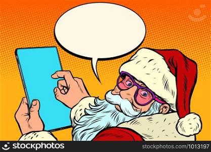 Santa Claus with a tablet. New year and Christmas online sales concept. merry Christmas and happy new year. Pop art retro vector illustration vintage kitsch drawing 50s 60s. Santa Claus with a tablet. merry Christmas and happy new year