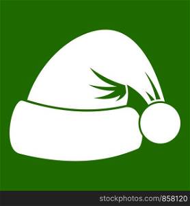 Santa hat icon white isolated on green background. Vector illustration. Santa hat icon green