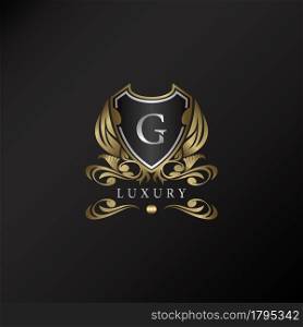 Shield logo in gold color with letter G Logo. Elegant logo vector template made of wide silver alphabet font on shield frame ornate style.