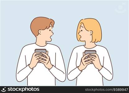 Shocked couple with phones surprised to read news or receive SMS mailing about bad weather. Embarrassed man and woman with phones surprised by posts or shared photos of partner on social media. Shocked couple with phones surprised to read news or receive SMS mailing about bad weather
