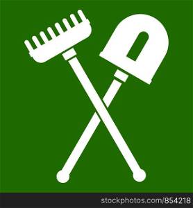 Shovel and rake icon white isolated on green background. Vector illustration. Shovel and rake icon green