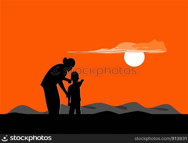 Silhouette of mother and son standing on the mountain watching the sunset.