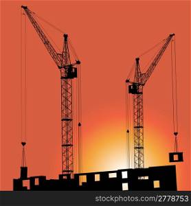 Silhouettes of crane on building against the backdrop of the sunset