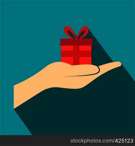 Small gift red box in a hand flat icon on a blue background. Small gift red box in a hand flat icon