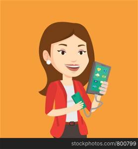 Smiling caucasian woman recharging her smartphone with mobile phone portable battery. Young woman holding a mobile phone and battery power bank. Vector flat design illustration. Square layout.. Woman reharging smartphone from portable battery.
