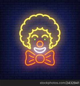 Smiling clown neon icon. Circus artist with big bow on dark brick wall background. Night bright advertisement. Vector illustration in neon style for entertainment or performance poster