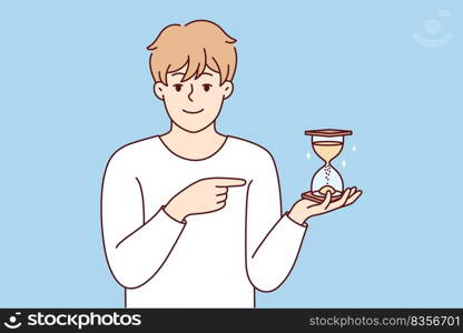 Smiling young man point at sandglass show sand flowing and time passing. Happy male show with finger and hourglass. Vector illustration.. Smiling man point at sandglass