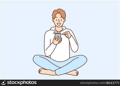 Smiling young man sit on floor using modern smartphone. Happy guy with cellphone browse internet or chat online on social media. Vector illustration. . Smiling man using cellphone 