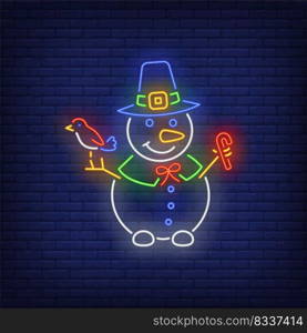 Snowman wearing witch hat, holding bird and candy cane neon sign. Winter season, Christmas design. Night bright neon sign, colorful billboard, light banner. Vector illustration in neon style.