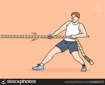 Strong man pulls rope while participating in sports competitions with rivals or training in fitness club. Strongman pulls rope alone, wanting to win tournament and get prize cup or medal.. Strong man pulls rope while participating in sports competitions or training in fitness club