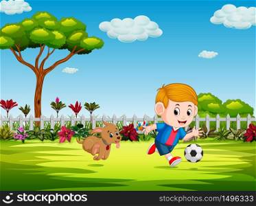 the boy playing soccer in the yard with his dog