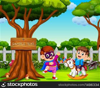 the boy uses the superhero costume and play with his friend near the big tree
