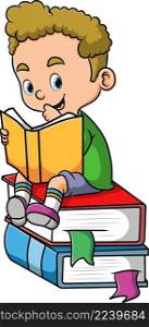 The cute boy is reading the book and sitting on the books