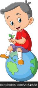 The happy boy with the small plant is sitting on the earth