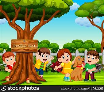 the happy children are playing near the big tree