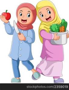 The two girls is holding the fruit and a pail of vegetables